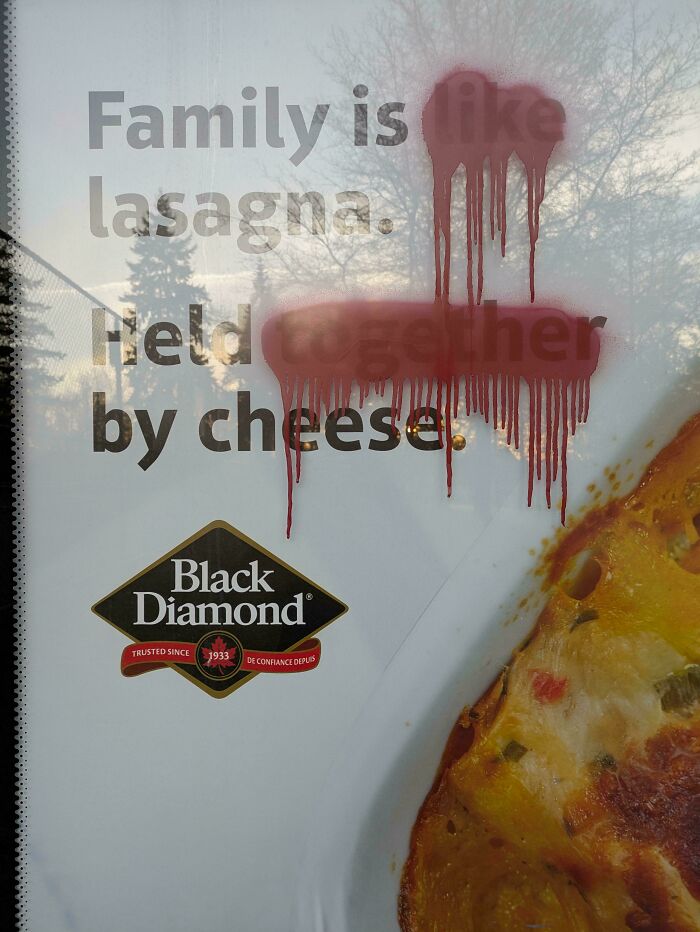 Bus stop ad defaced with red paint but still shows wholesome wholesome vandalism making streets look better concept.