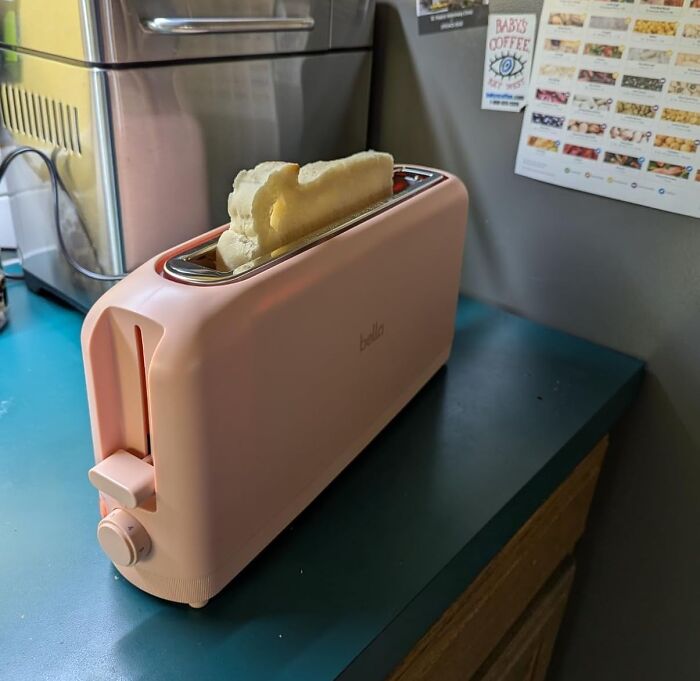 Pink toaster with bread slices inside sitting on a kitchen counter showcasing smart kitchen gadgets for upgrading kitchen IQ.