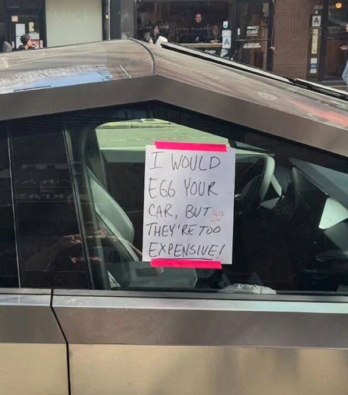 Handwritten sign on car window humorously states reluctance to egg the vehicle, showcasing wholesome street vandalism.