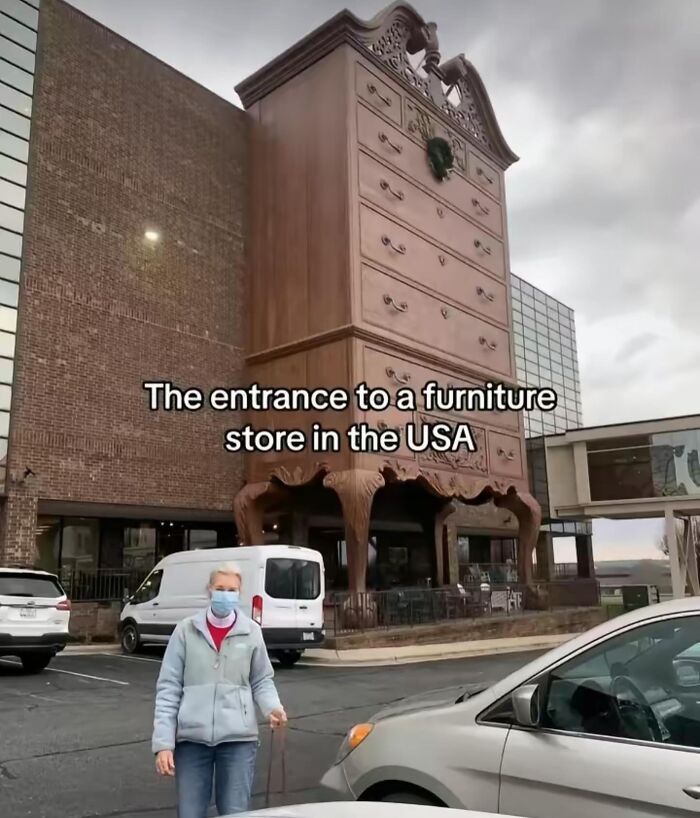 Entrance of a furniture store shaped like a giant wooden chest of drawers, showing interesting and unique design details.