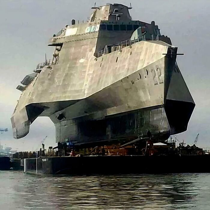 Massive, scarily big futuristic warship docked at a port, showcasing megalophobia with its intimidating size and design.