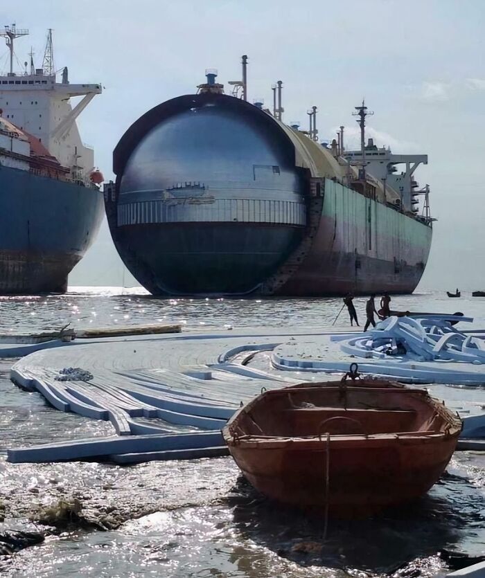 Massive spherical cargo ship docked near small boats, highlighting the scarily big scale for megalophobia enthusiasts.