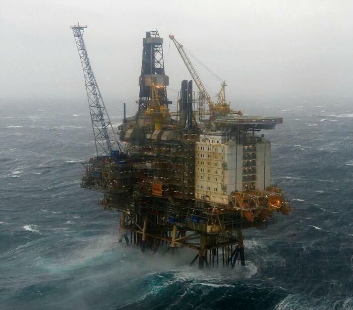 Massive offshore oil rig standing tall above rough ocean waves, illustrating an example of megaphobia with its scarily big structure.