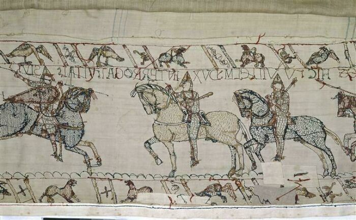 Medieval embroidered tapestry showing mounted knights in battle, an alternate angle of an iconic historical event.