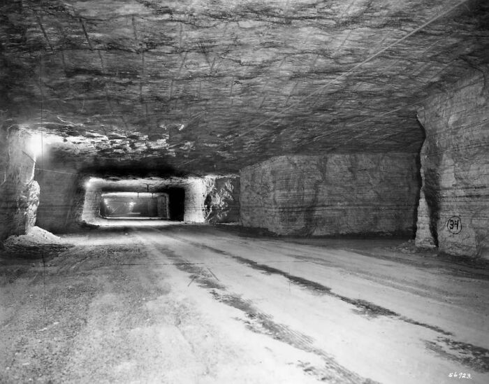 Underground tunnel showing alternate angles of historic limestone excavation site with rough rock walls and ceiling.