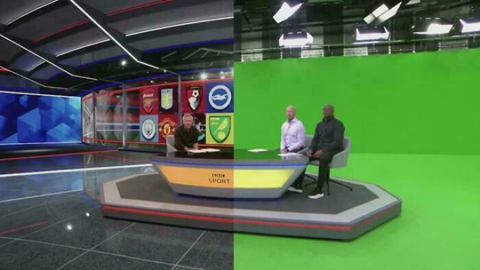 Sports news anchors in a studio shown from an alternate angle revealing the green screen background and production setup.
