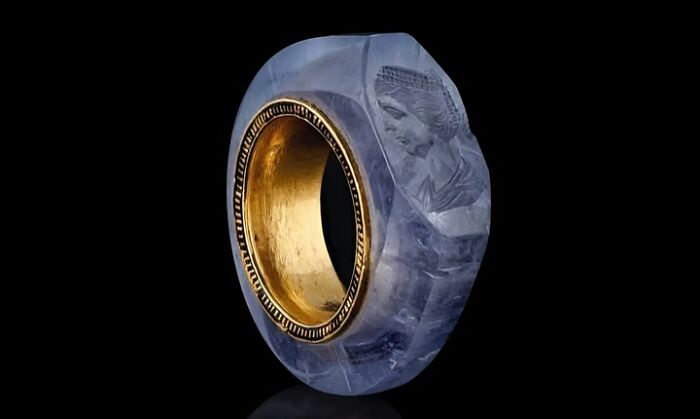 Ancient carved sapphire ring with gold interior, showcasing intricate details and craftsmanship from archaeology news.