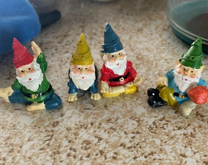 Four colorful garden gnome figurines sitting on a countertop, perfect for outdoor upgrades in your backyard.