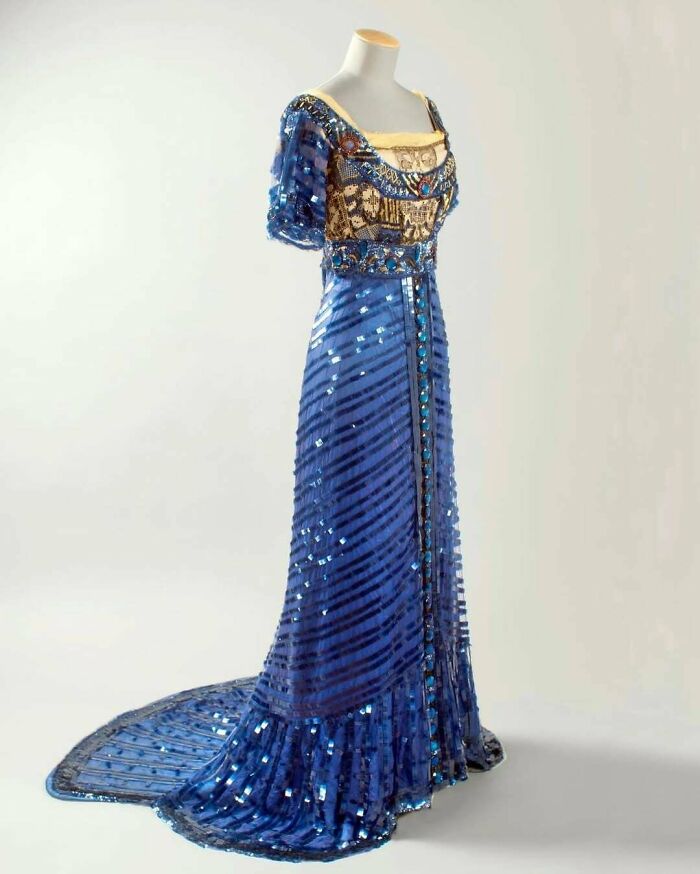 Blue vintage gown with intricate beadwork and sequins, showcasing centuries of fashion history on a mannequin.