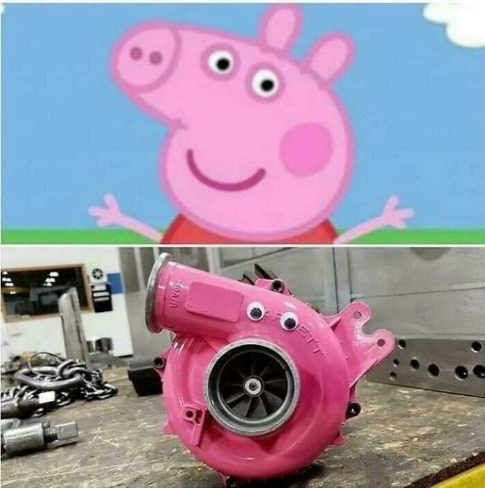 Pink turbocharger with googly eyes resembling a cartoon character in a workshop, a blursed image that may short-circuit your brain.