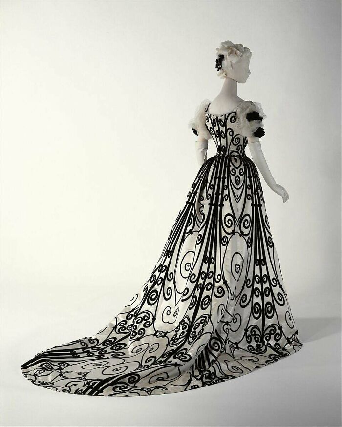 Victorian inspired black and white gown with intricate swirls, showcasing centuries of fashion in a stunning vintage style.