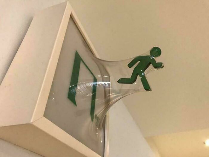 Exit sign with figure stretched out of the frame, creating a blursed visual effect that confuses the brain.