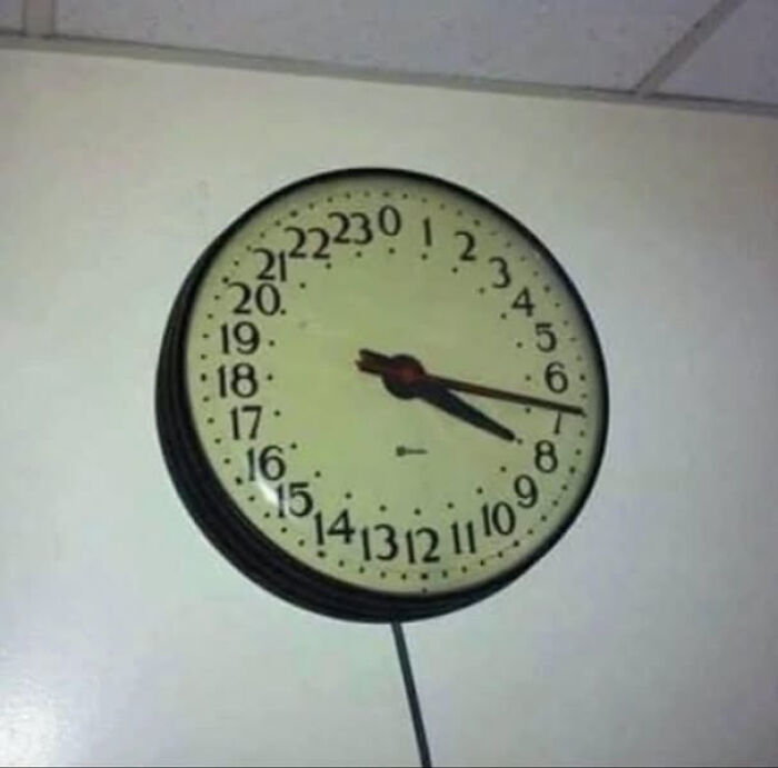 Round wall clock with 24-hour numbers arranged counterclockwise, a blursed image that may confuse the brain.