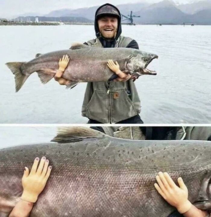 Man holding a huge fish with tiny hands attached to it creating a blursed optical illusion effect outdoors.