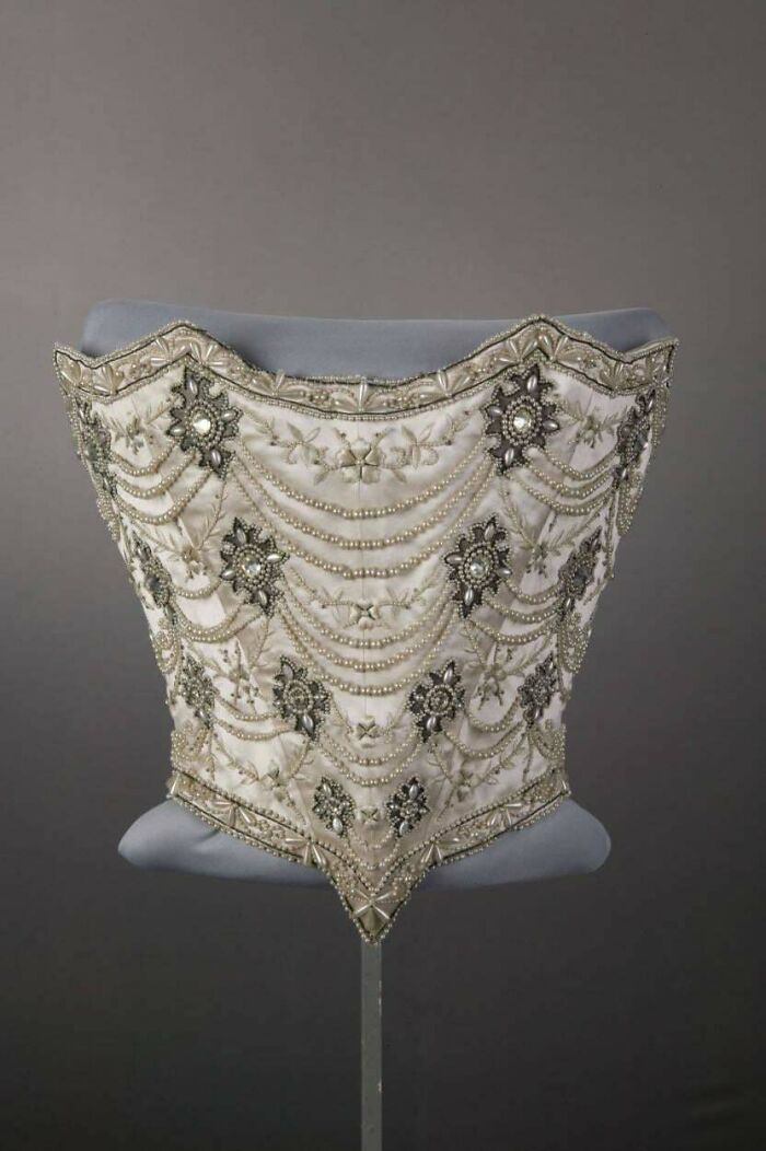 Vintage corset featuring intricate beadwork and embroidery, showcasing centuries of fashion history in detailed design.