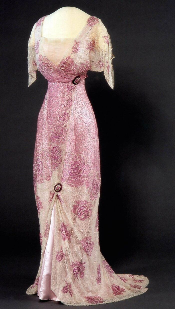 Vintage pink evening gown with floral patterns and beading, showcasing centuries of fashion history in elegant design.