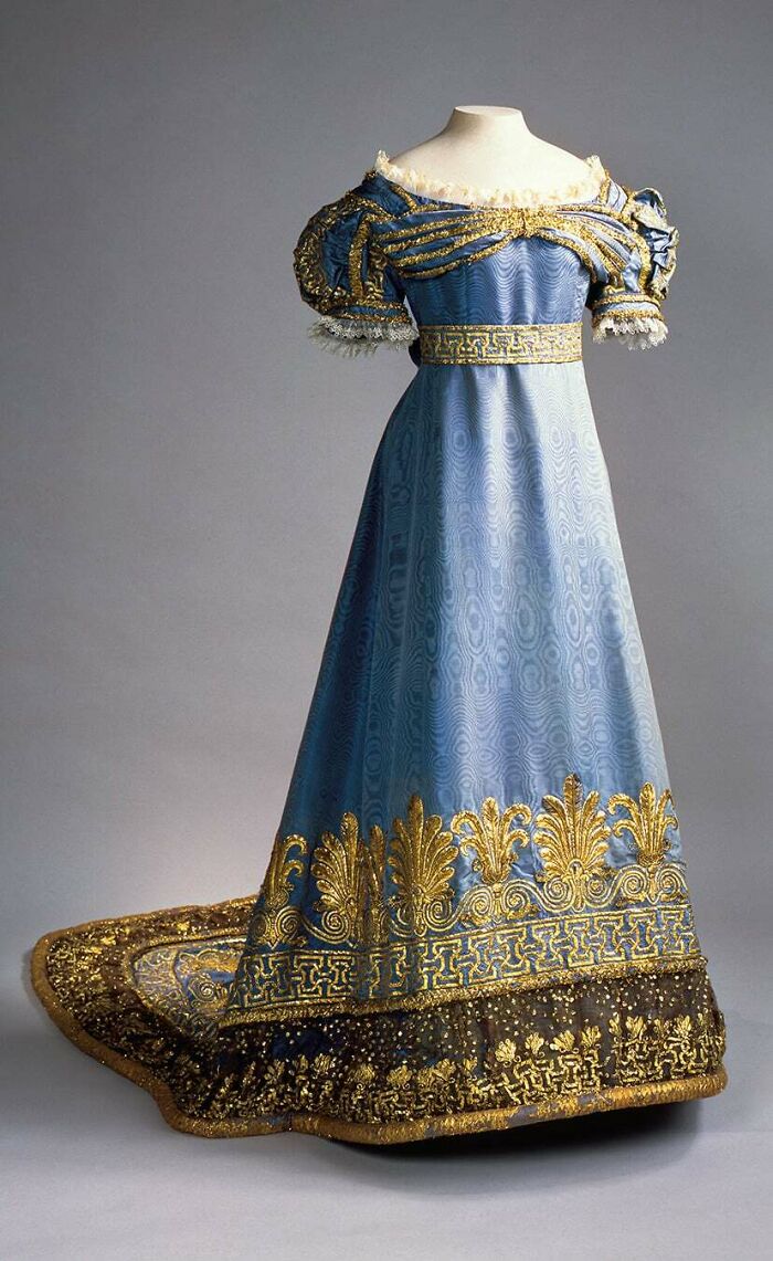 Regal blue and gold historical dress showcasing centuries of fashion with intricate embroidery and elegant design details.