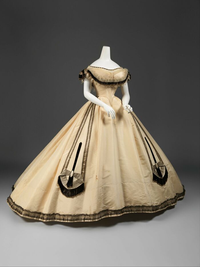 Victorian century fashion dress with wide skirt and off-shoulder neckline, showcasing centuries of fashion history.