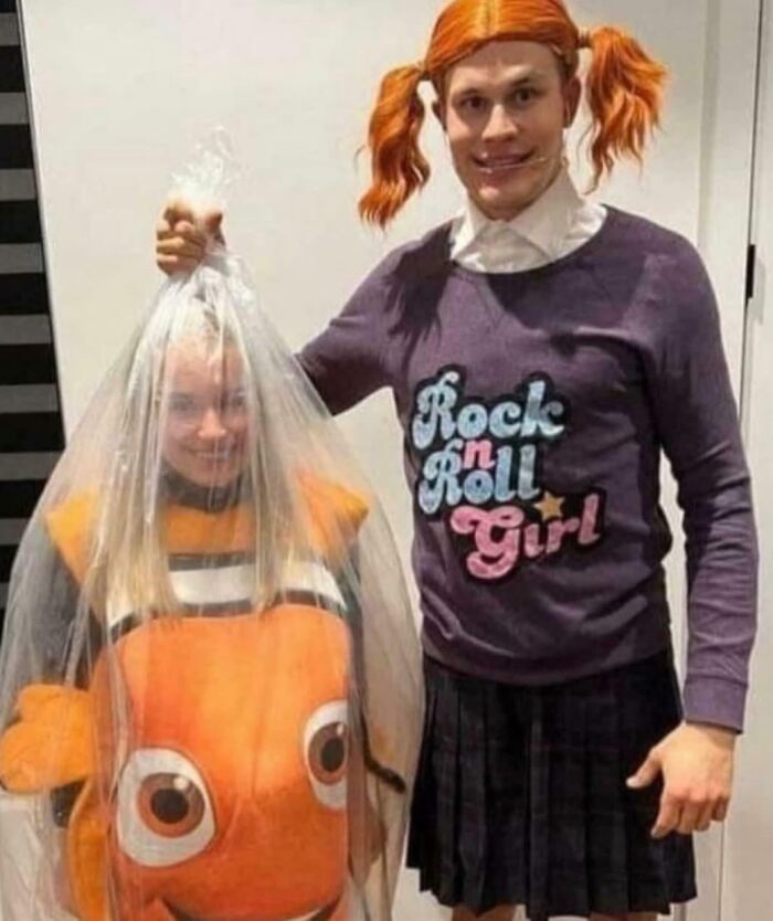 Two people in blursed costumes, one dressed as a fish inside a plastic bag, the other with red pigtails and a skirt.