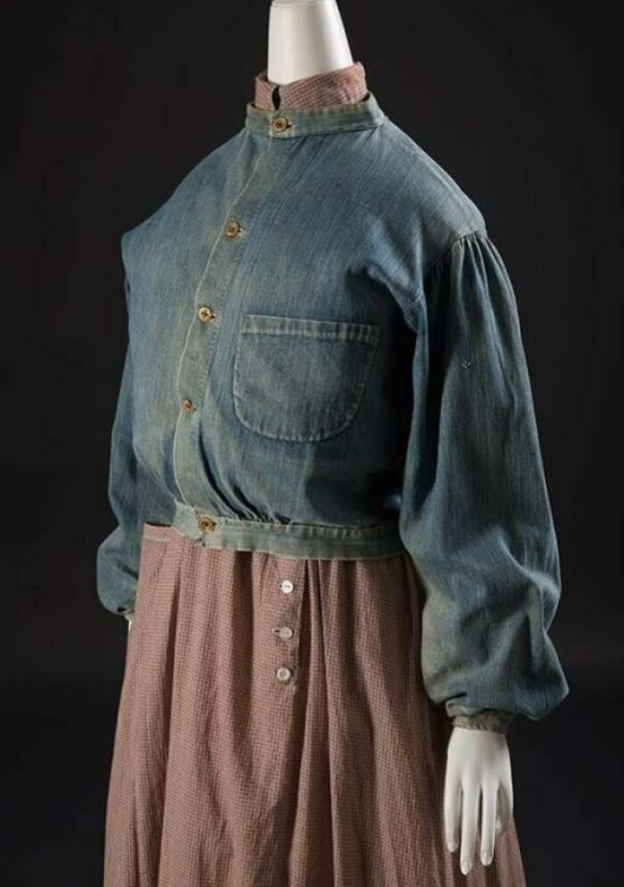 Vintage denim jacket with puffed sleeves over a brown checkered dress showcasing centuries of fashion history.