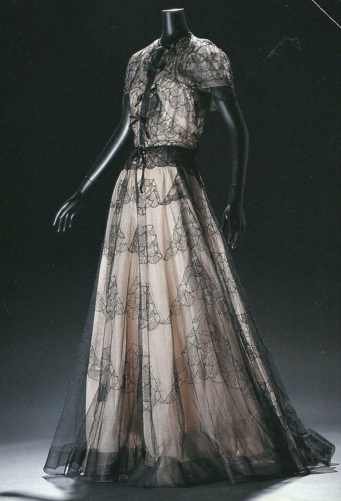 Vintage black lace evening gown on a mannequin showcasing centuries of fashion in an elegant design.