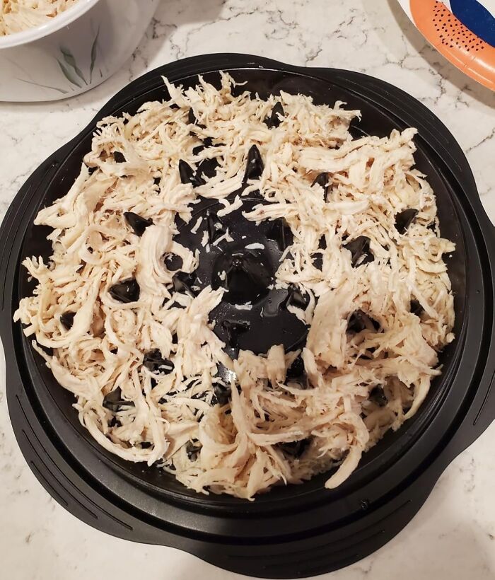 Shredded chicken on an Amazon affordable finds black plastic kitchen gadget on a marble countertop.