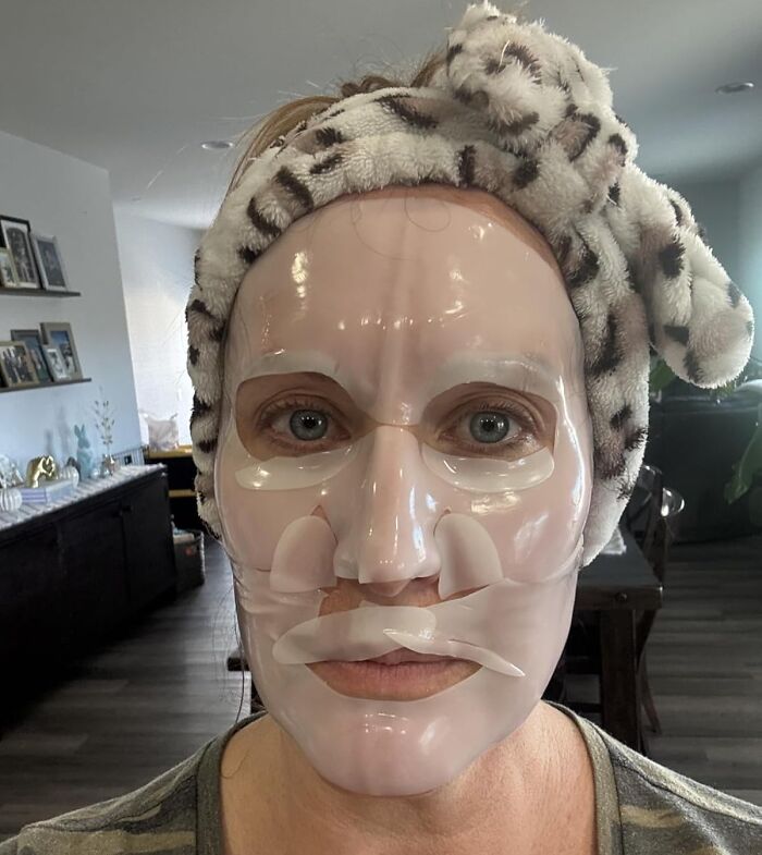 Person wearing a hydrating facial sheet mask and a leopard print headband, one of the affordable finds on Amazon.