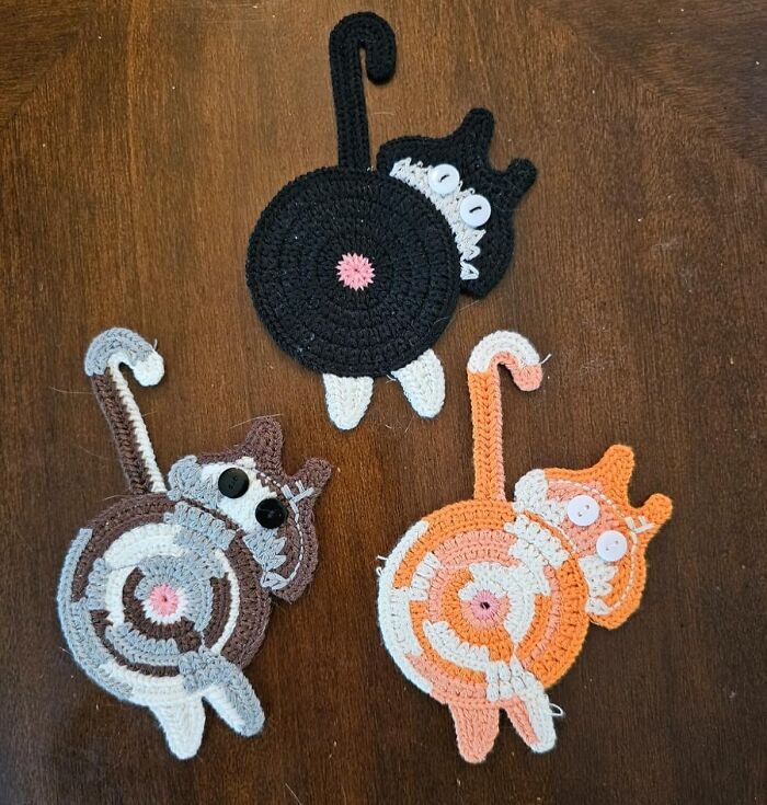Crocheted cat coasters in black, brown, and orange colors, showcasing weirdly wonderful finds for home decor enthusiasts.