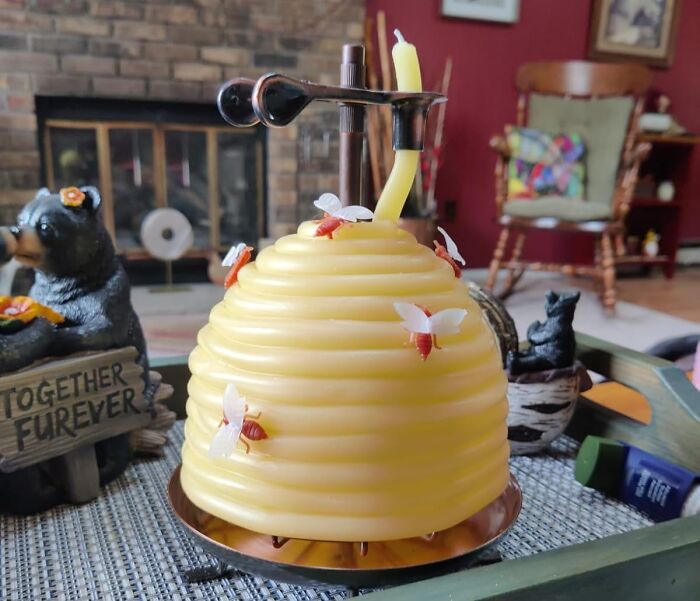 Yellow beehive-shaped candle with decorative bees, a weirdly wonderful find on a living room tray with cozy decor.