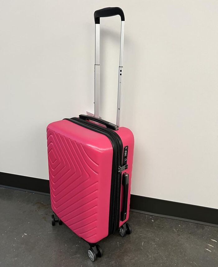 Bright pink hard-shell suitcase with an extended handle and four wheels, a perfect Mother's Day splurge gift idea.