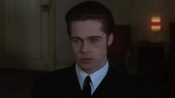 Actor Brad Pitt in a dark suit and tie portraying a serious scene from a classic movie behind-the-scenes moment.