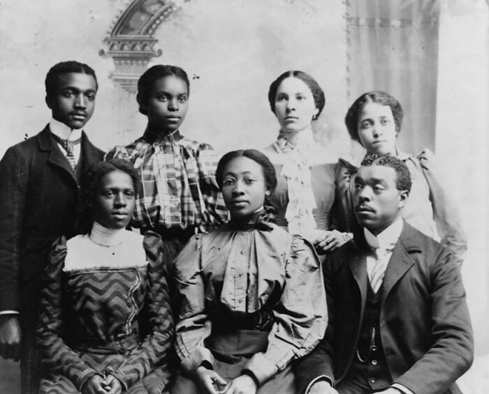 Group of African American men and women dressed in formal attire, captured during the 1900 Paris Exposition.
