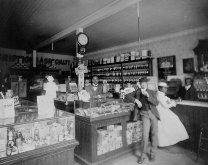 African American life captured in a 1900 Paris Exposition photo showing people inside a vintage store setting.