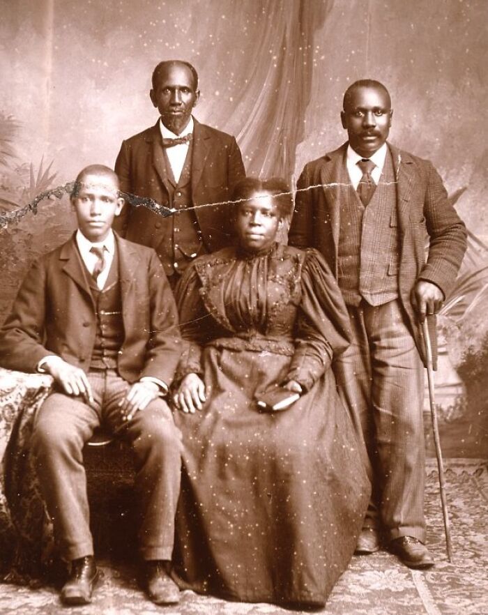 Group of African American men and a woman dressed formally in late 19th century attire, capturing African American life.