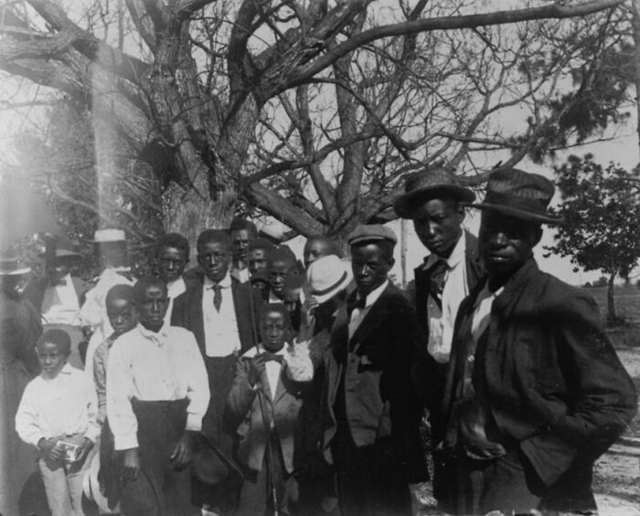 Group of African American men and boys in early 1900s clothing, capturing African American life at the 1900 Paris Exposition.