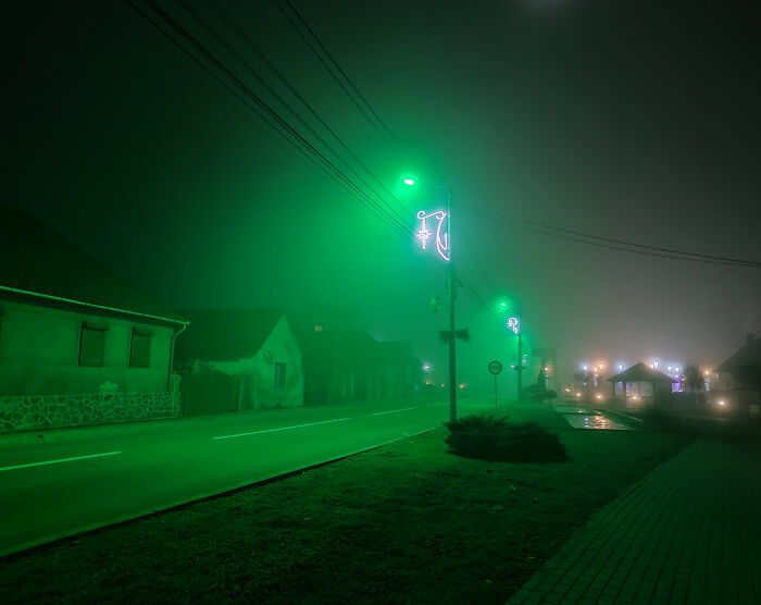 Foggy street at night illuminated by green lights, creating a creepy atmosphere that people found unsettling to share.