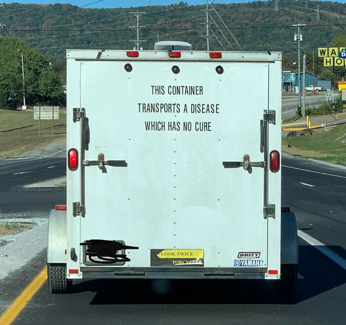 Trailer on the road with a creepy warning message about transporting a disease with no cure seen by people sharing creepy moments