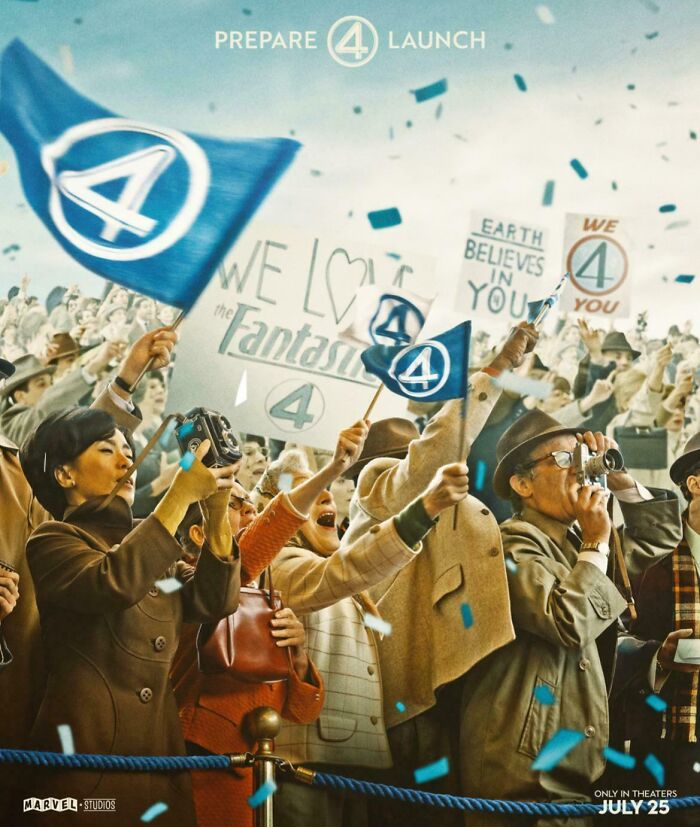 Crowd waving Fantastic Four flags and holding signs at a movie launch event, highlighting questionable movie details.