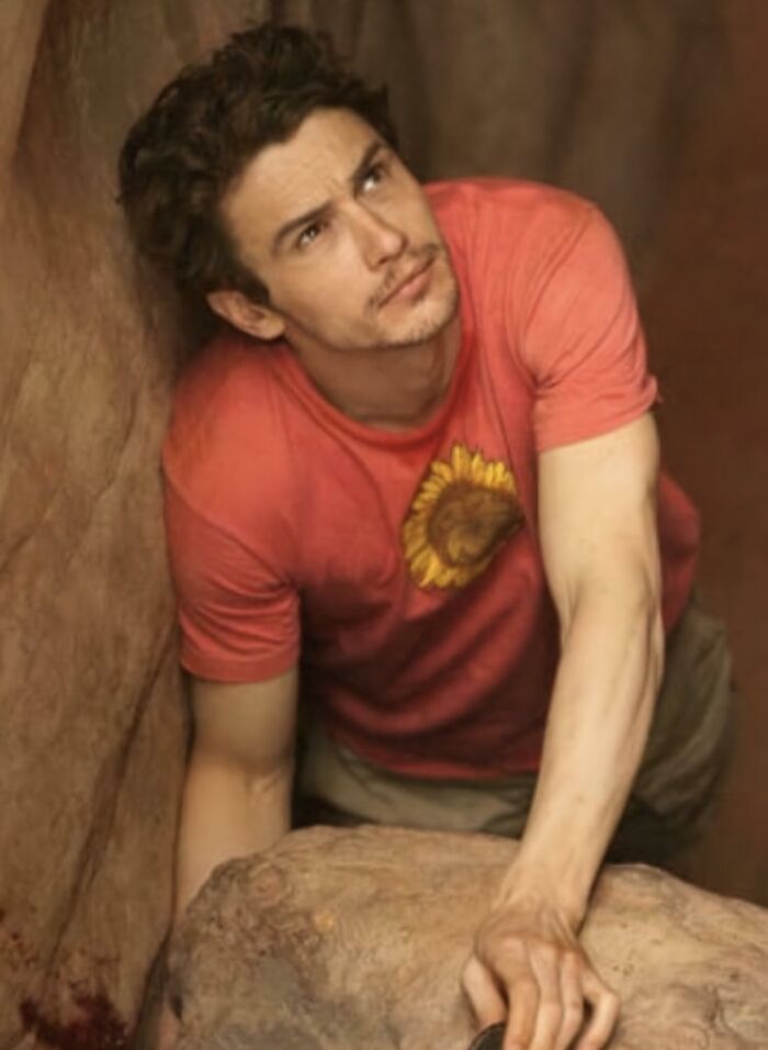 Young man in a red shirt climbing rocks, illustrating questionable movie details that cinephiles mock online.