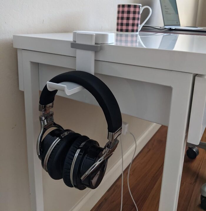 Headphone holder attached to a white desk, showcasing a practical desk find to enhance your Monday workspace.