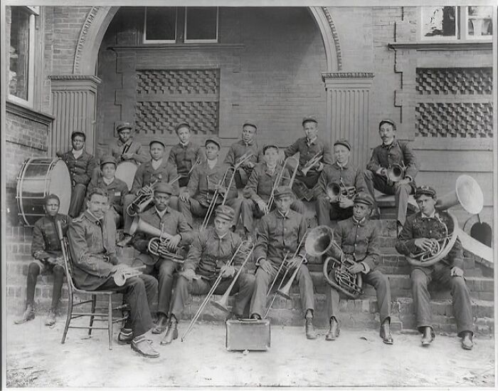 African American brass band members posing with instruments at the 1900 Paris Exposition capturing life moments.