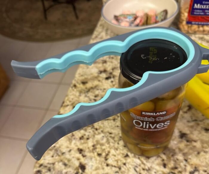 Jar opener tool gripping a glass jar lid on a kitchen counter, an affordable home find for easy living.