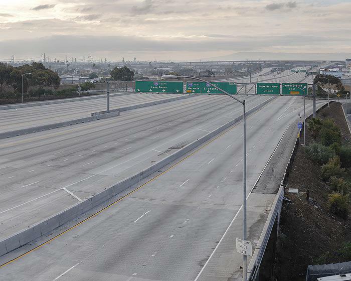 Empty highway lanes stretch into the distance, showcasing unsettling yet fascinating empty spaces on a cloudy day.