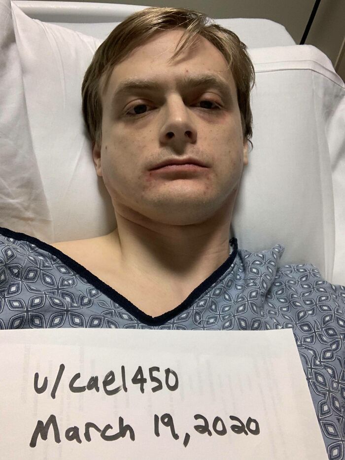 Man lying in hospital bed wearing a gown, holding a sign with username and date, part of people who asked internet to toast them.