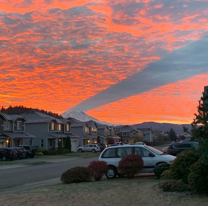 Sunset sky showing one-in-a-million coincidences with mountain shadow perfectly aligned over a suburban neighborhood.