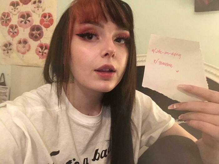 Young woman holding a note asking for internet toast, part of a series with nicest comments from online community.
