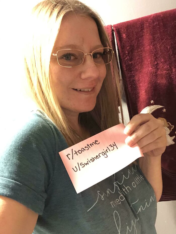 Woman wearing glasses holding a note for toastme, part of 80 people who asked the internet to toast them with kind comments.