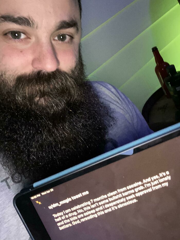 Bearded man holding a tablet showing a request for a toast, part of popular internet toasting comments posts.