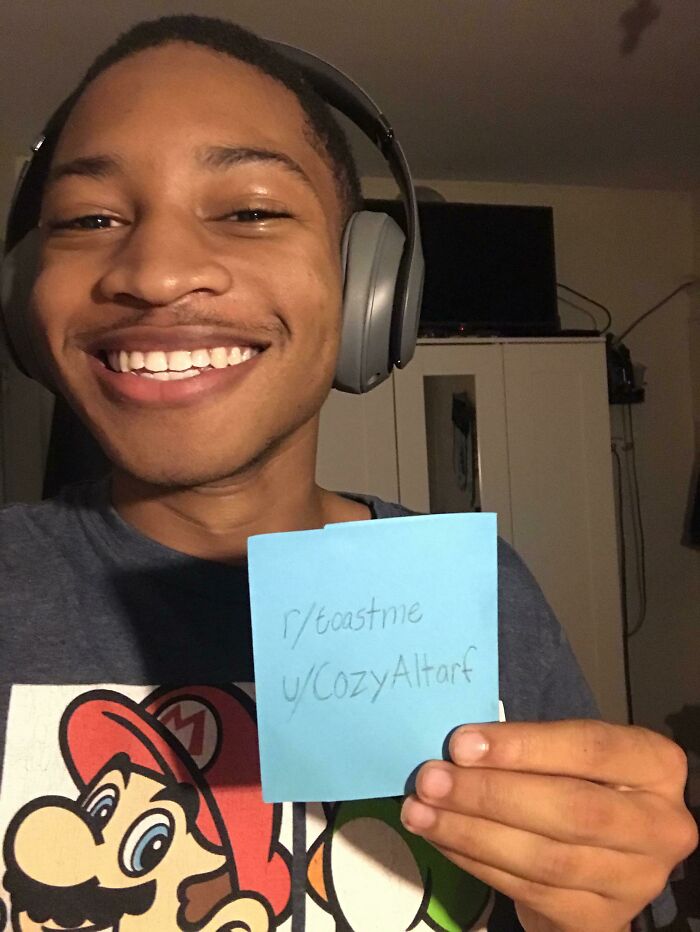 Smiling young man wearing headphones holding a toast request note, part of internet toast comments collection.
