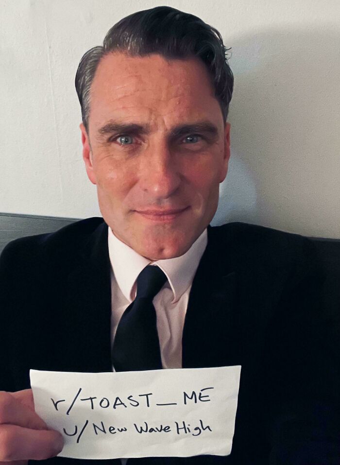 Man in a suit holding a sign asking to be toasted, part of internet toast thread with nicest comments ever.